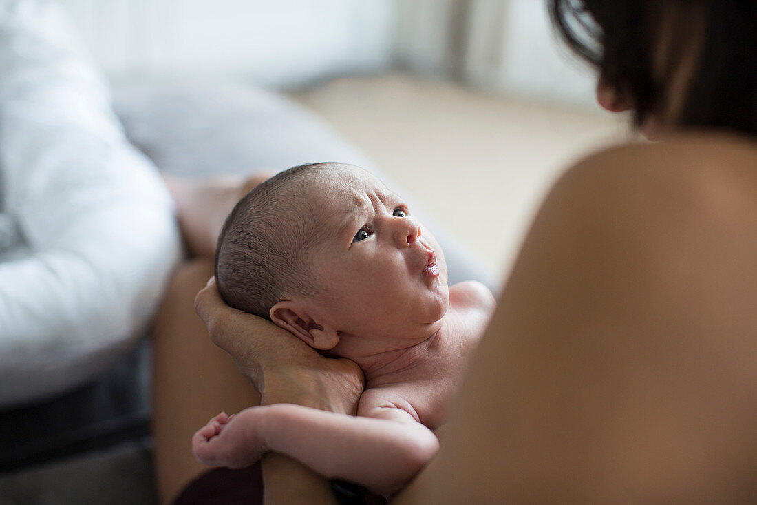 Mother holding cute fussy newborn baby boy