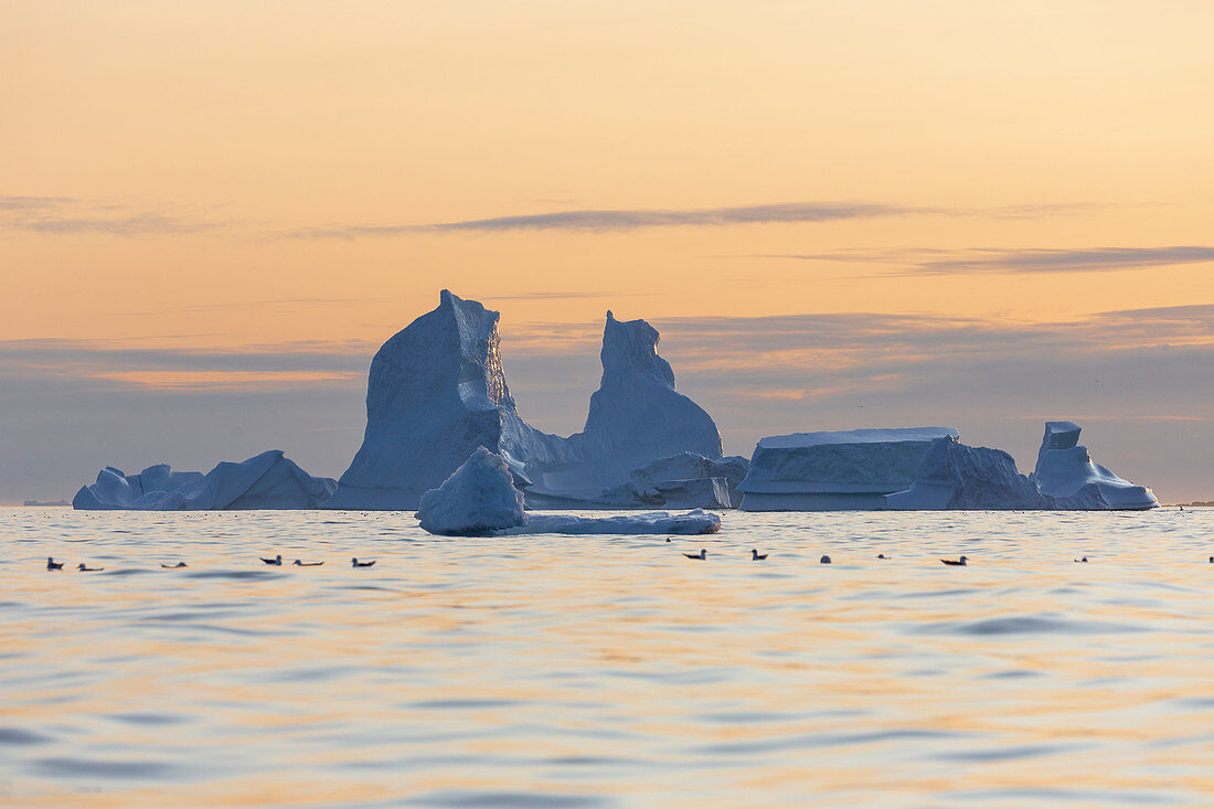 Majestic iceberg formations over sunset