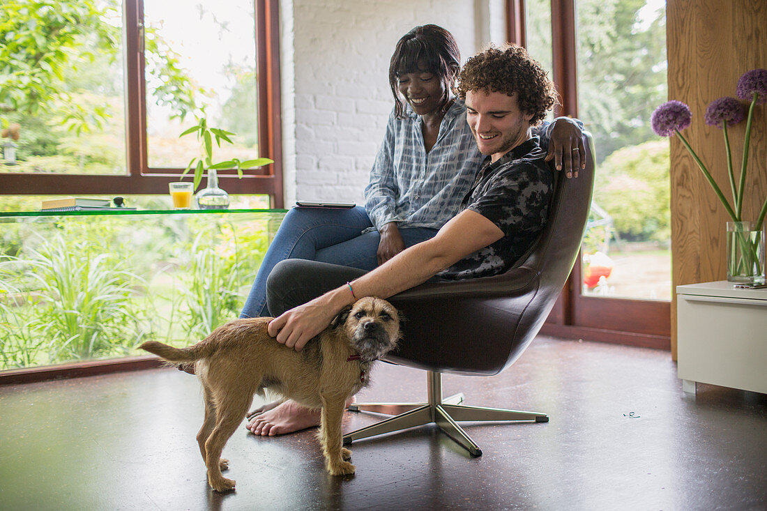 Happy couple with dog in home office