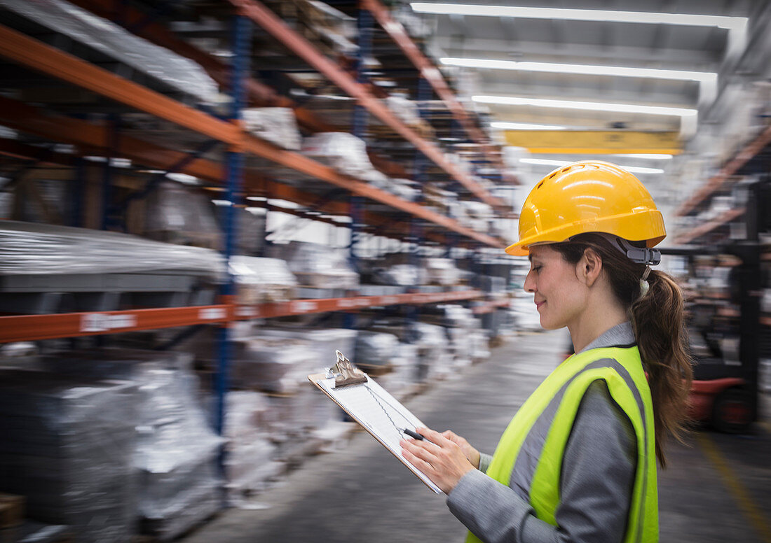 Female supervisor checking inventory in steel warehouse