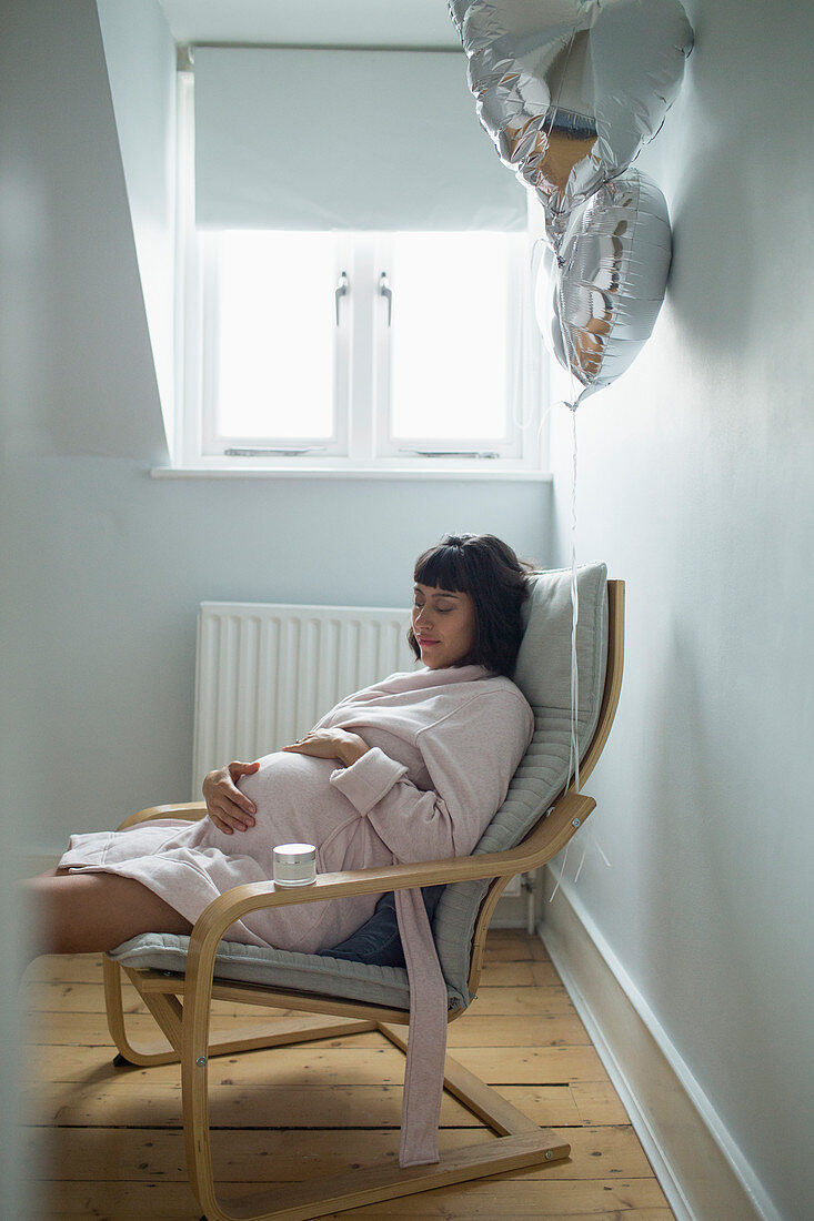 Serene pregnant woman in bathrobe relaxing