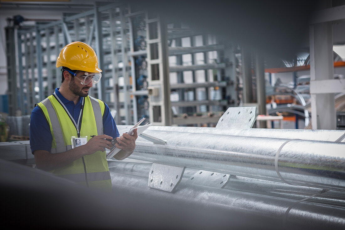 Male worker using digital tablet in steel factory