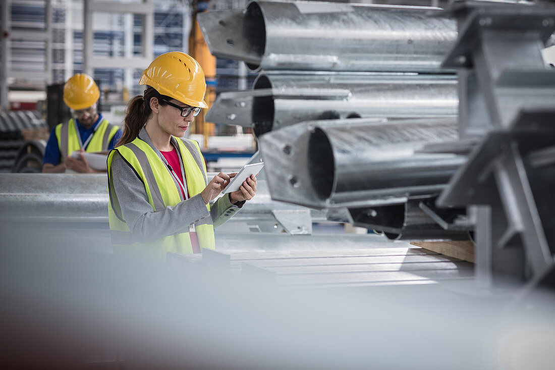 Female supervisor using digital tablet in steel factory