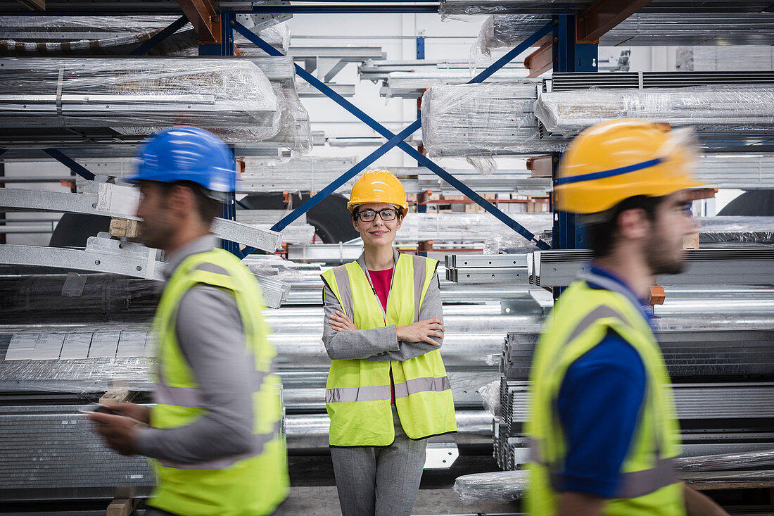 Confident, smiling female supervisor in steel factory
