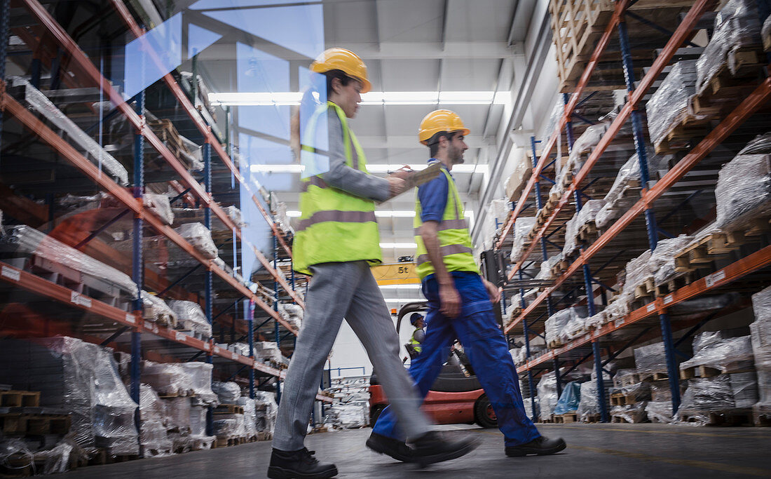 Workers with clipboard walking in warehouse
