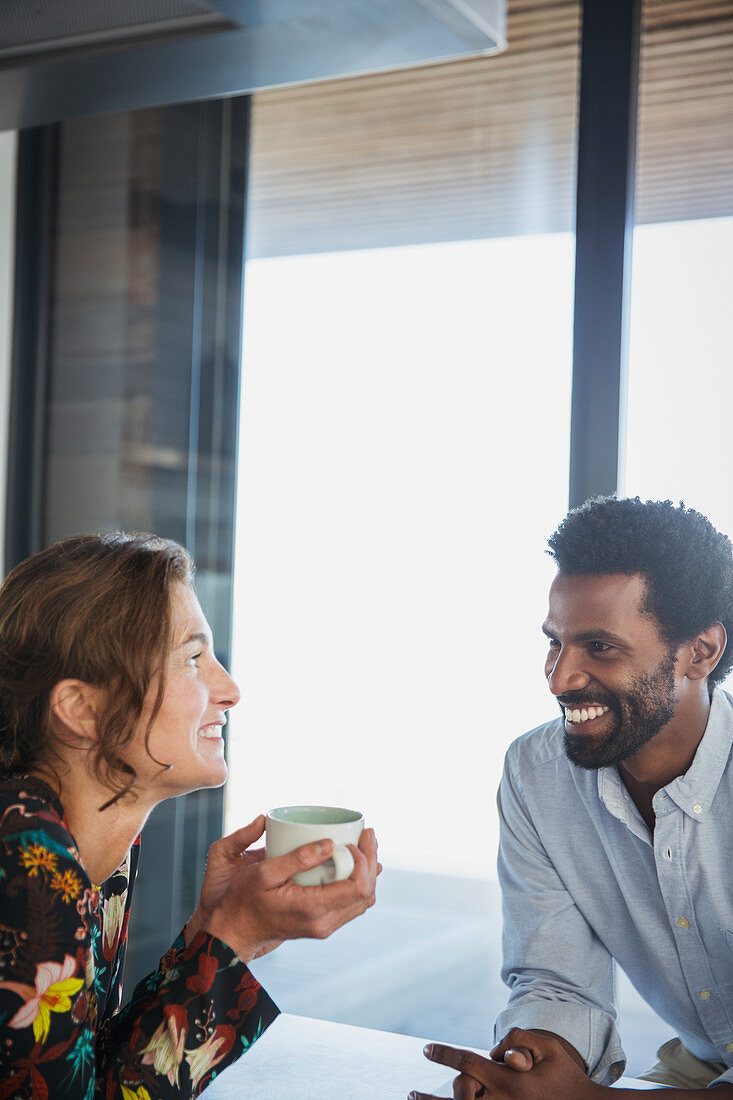 Multi-ethnic couple drinking coffee and talking