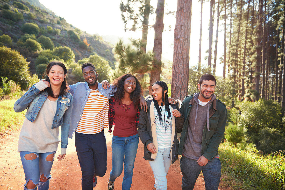 Young friends walking in a row in woods