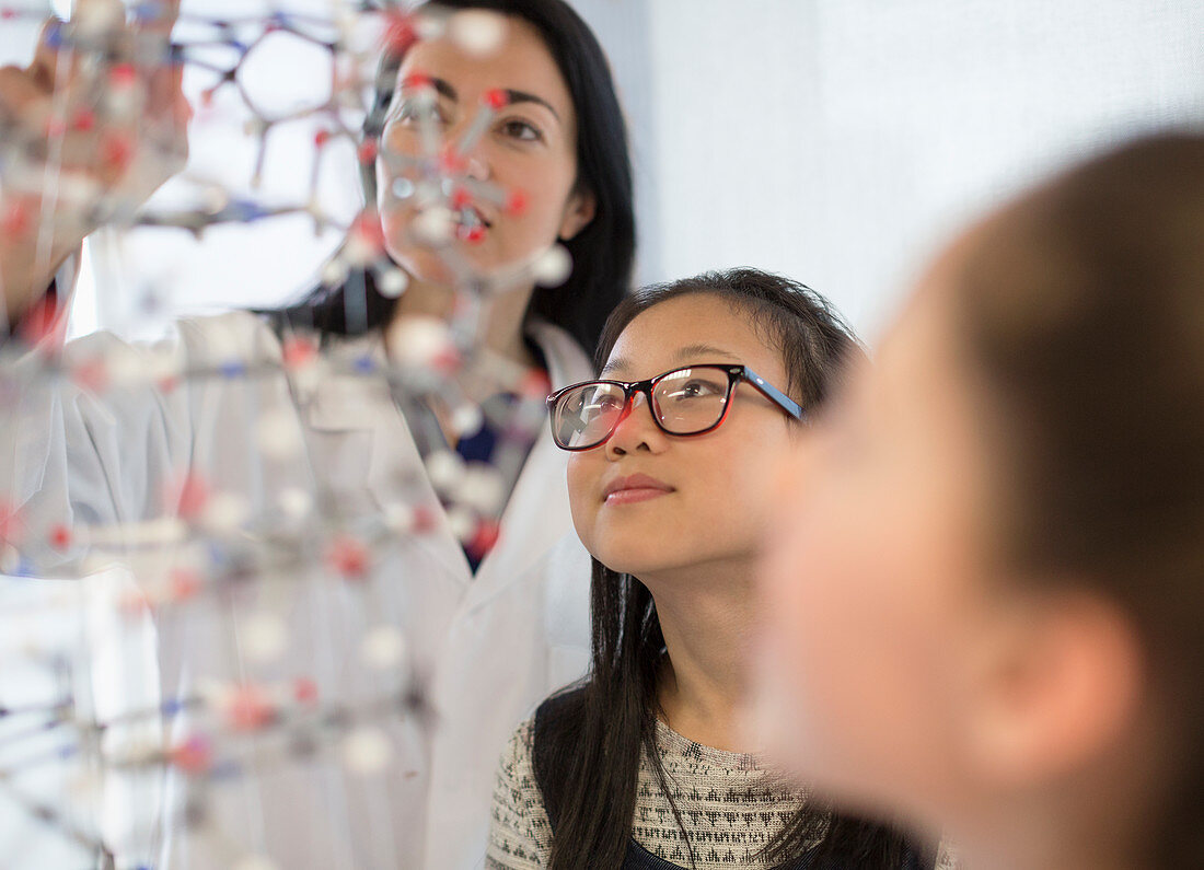 Teacher and girl students examining molecular structure