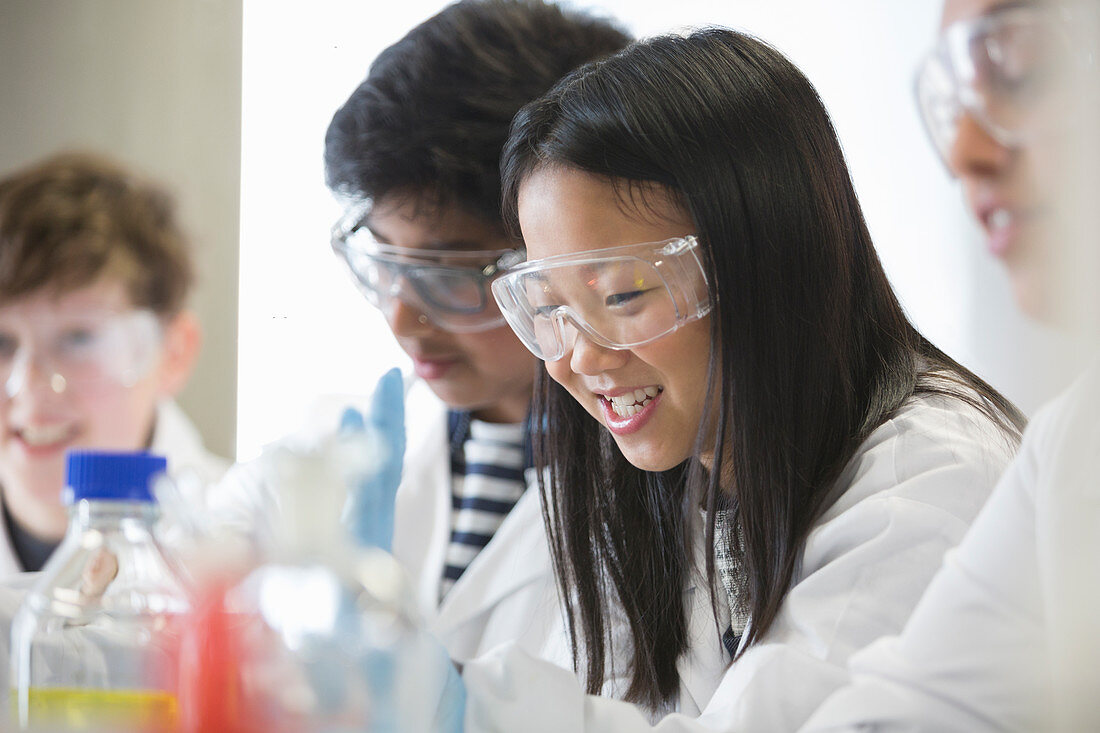 Smiling girl conducting scientific experiment in classroom