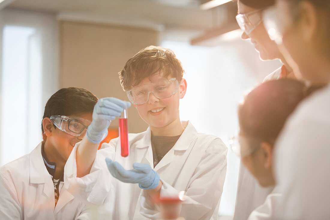 Students examining liquid in test tubein classroom