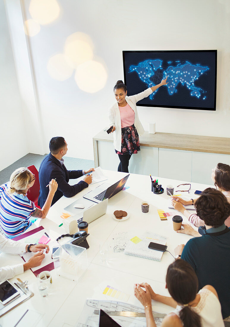 Businesswoman at television screen leading meeting