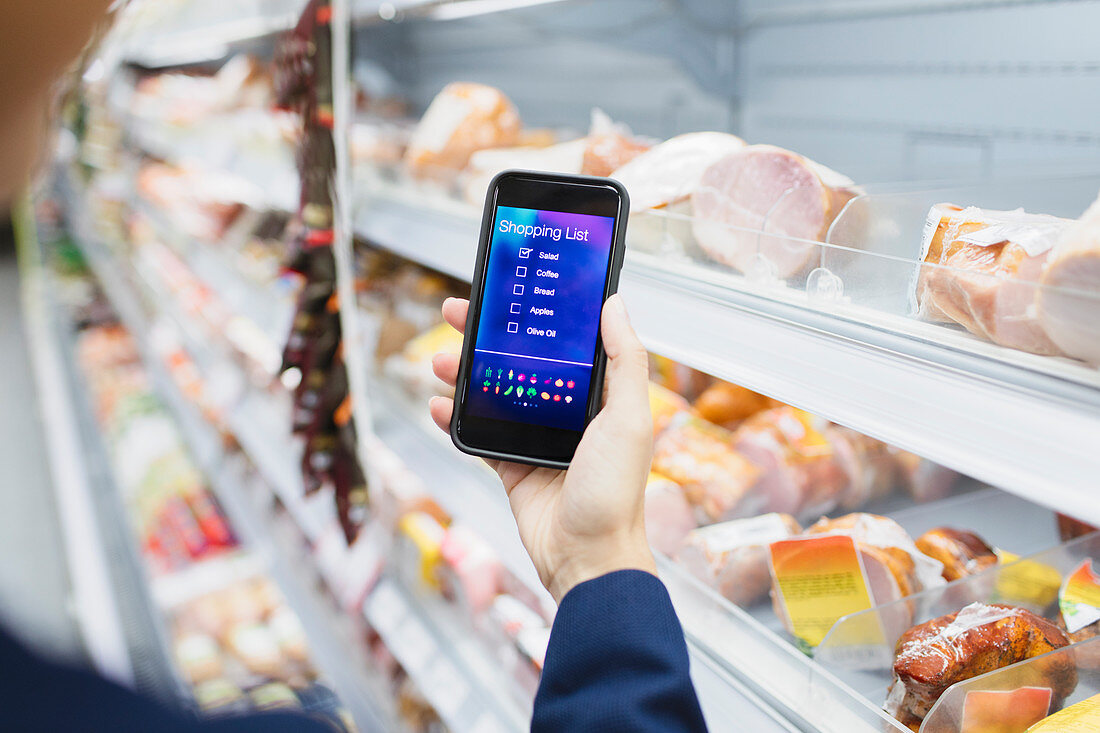 Woman using digital shopping list on camera phone