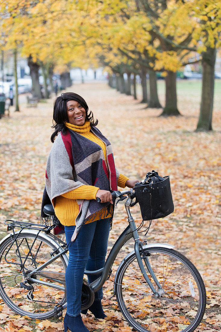 Portrait smiling, confident woman bike riding among trees