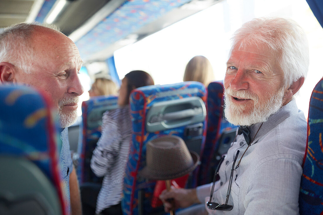 Smiling, confident active senior men tourist on tour bus