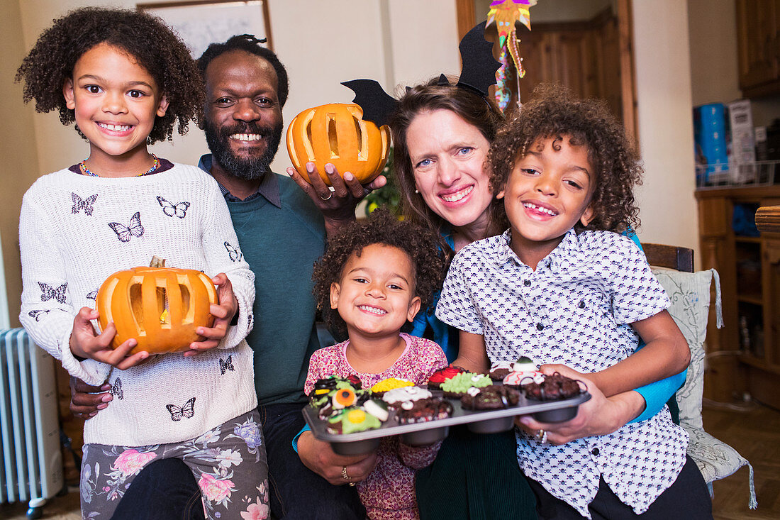 Happy family with carved pumpkins and Halloween cupcakes