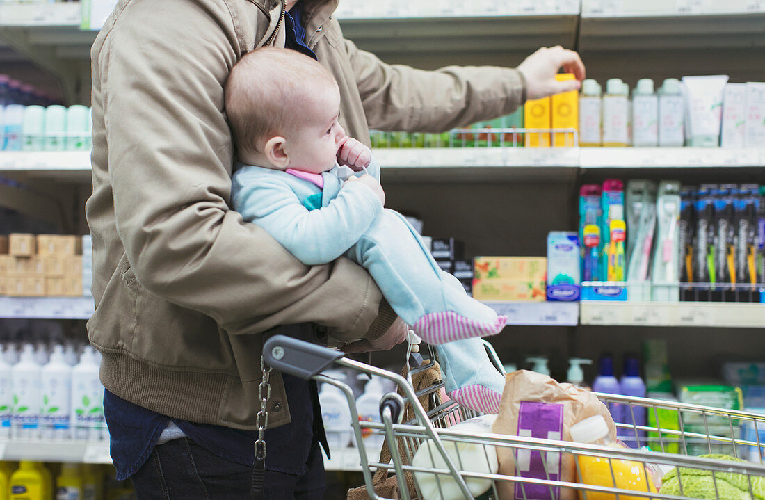 Father with baby shopping in supermarket