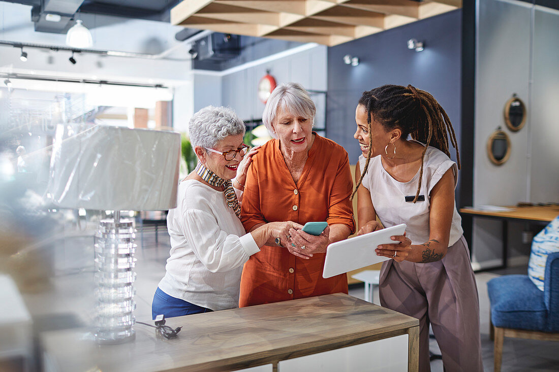 Woman helping customers shopping in home decor shop