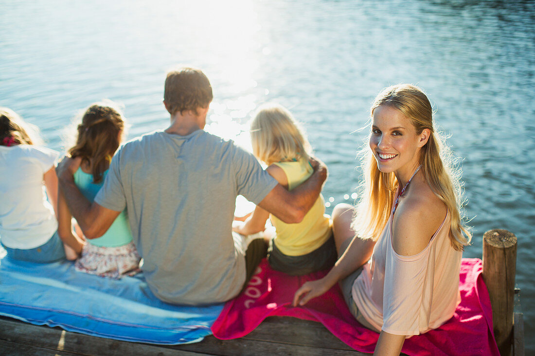Smiling woman with family on dock over lake