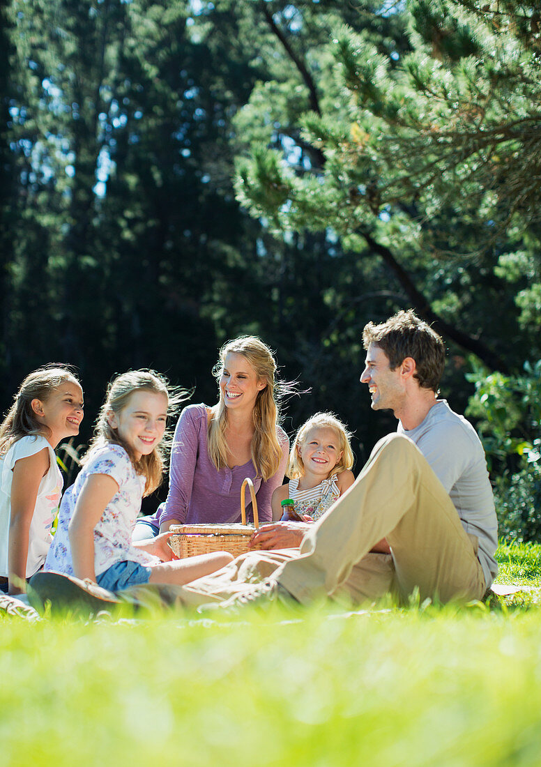 Smiling family picnicking in grass