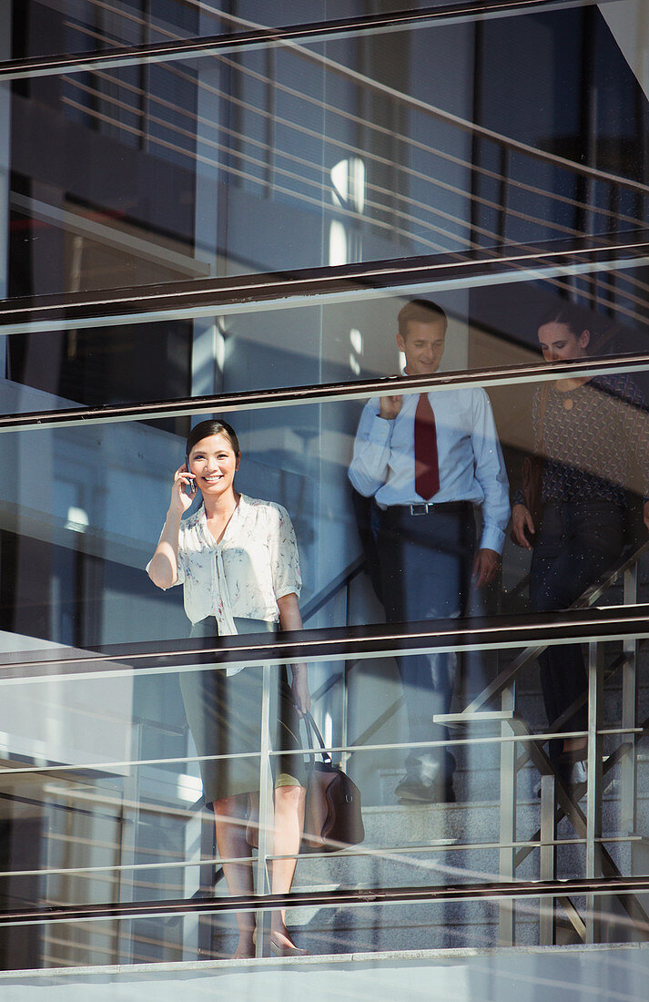 Smiling businesswoman using cell phone at window