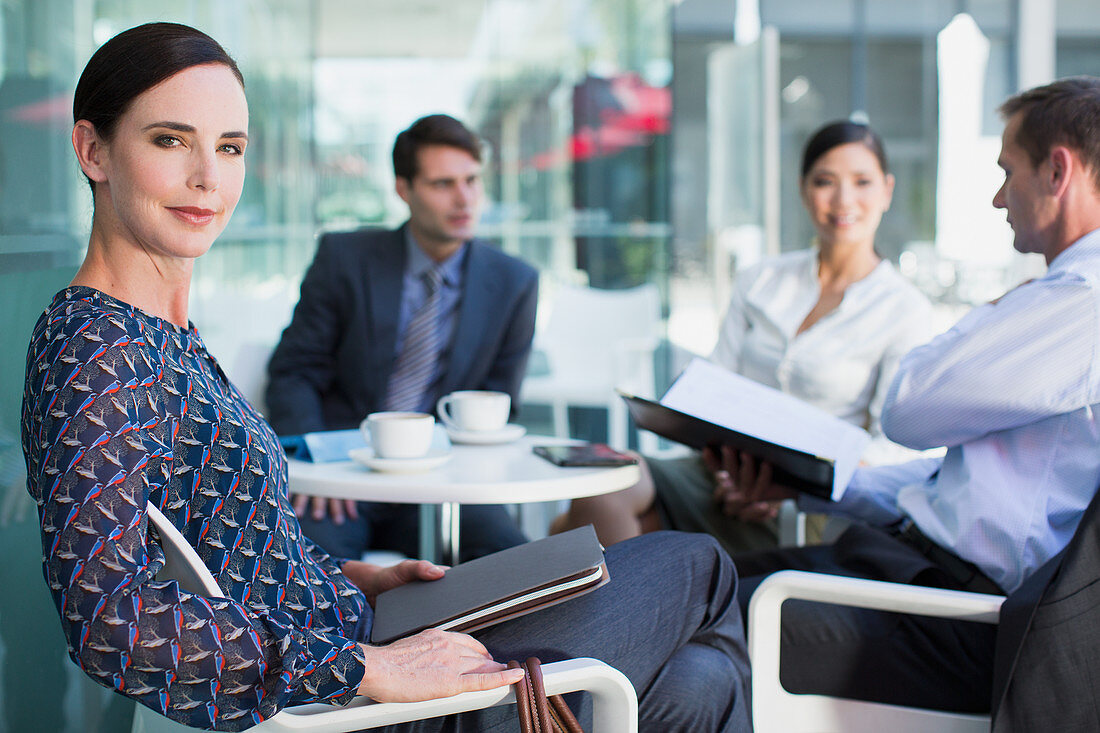 Confident businesswoman in meeting at cafe