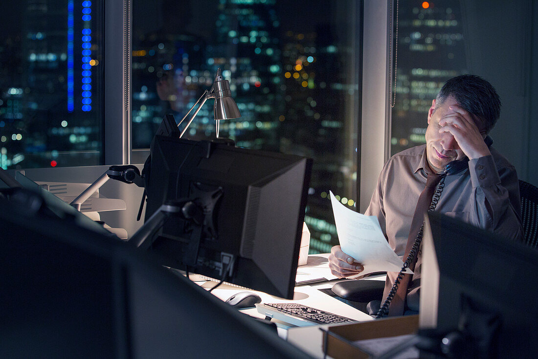 Stressed businessman working late in office