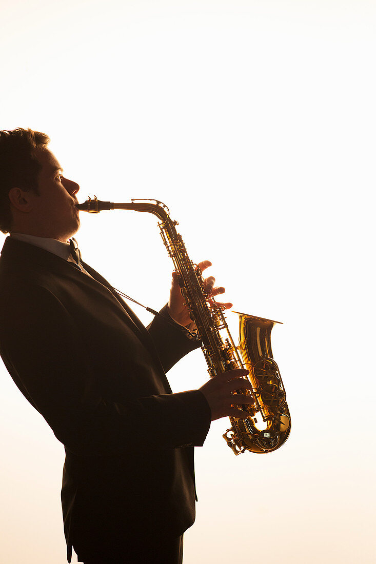 Silhouette of saxophonist performing