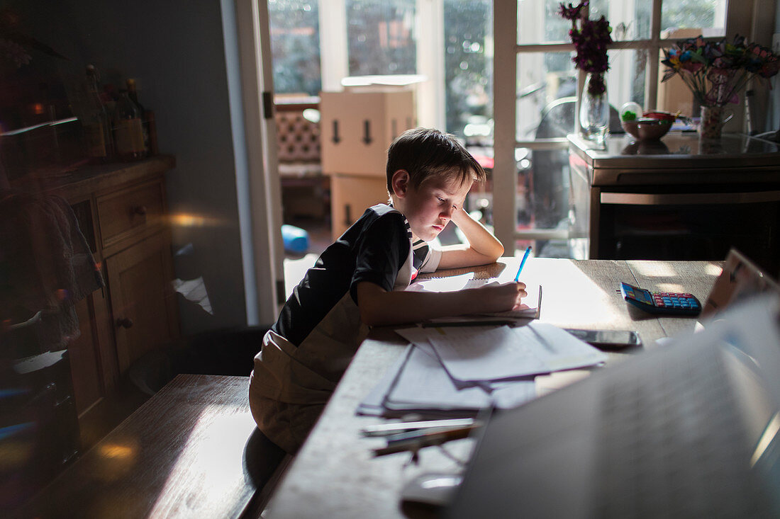 Boy doing homework at dining table