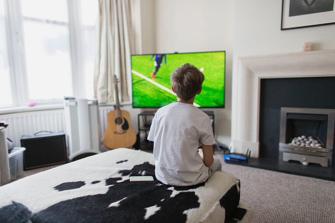 Boy watching soccer match on TV in living room