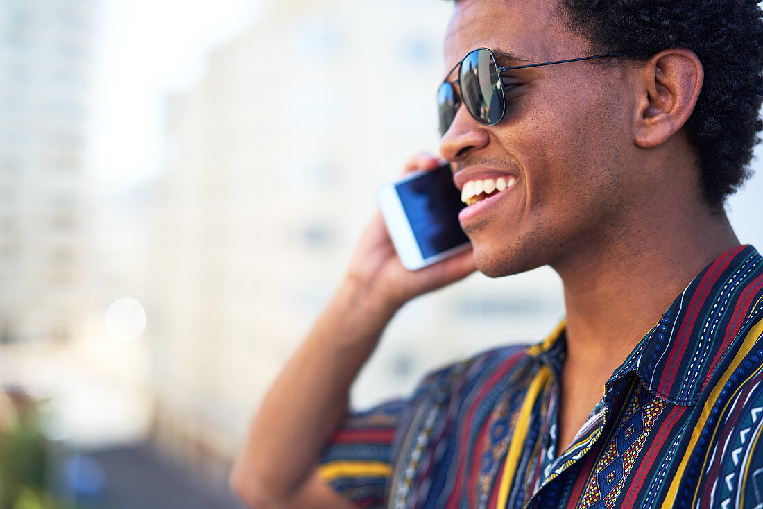 Smiling young man talking on smart phone