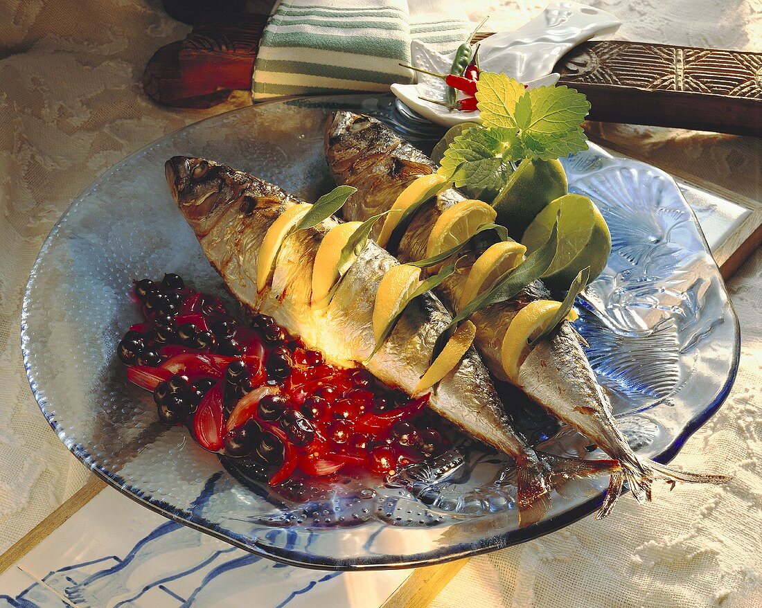 Geräucherte Makrelen mit Zitrone gespickt auf Beerensauce