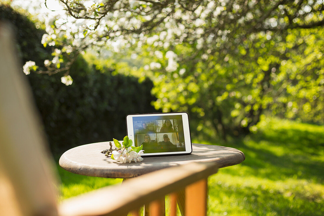 Friends video chatting on digital tablet screen in garden