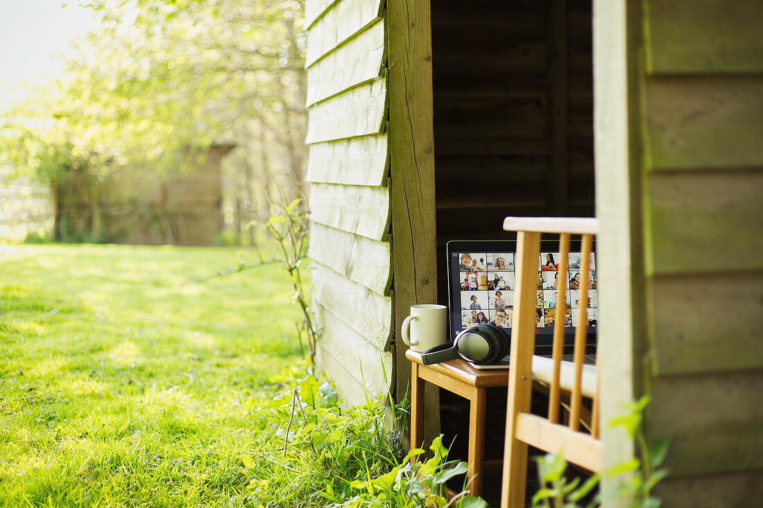 Friends video chatting on laptop screen in sunny garden shed