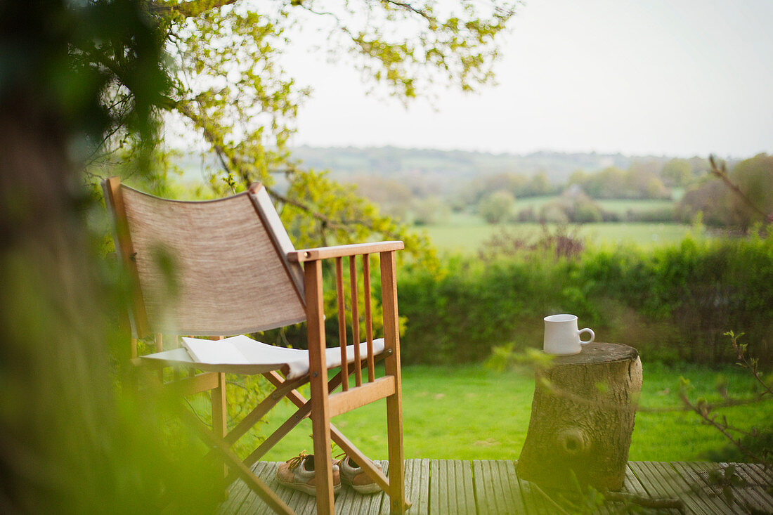 Chair and coffee on tranquil balcony overlooking rural field