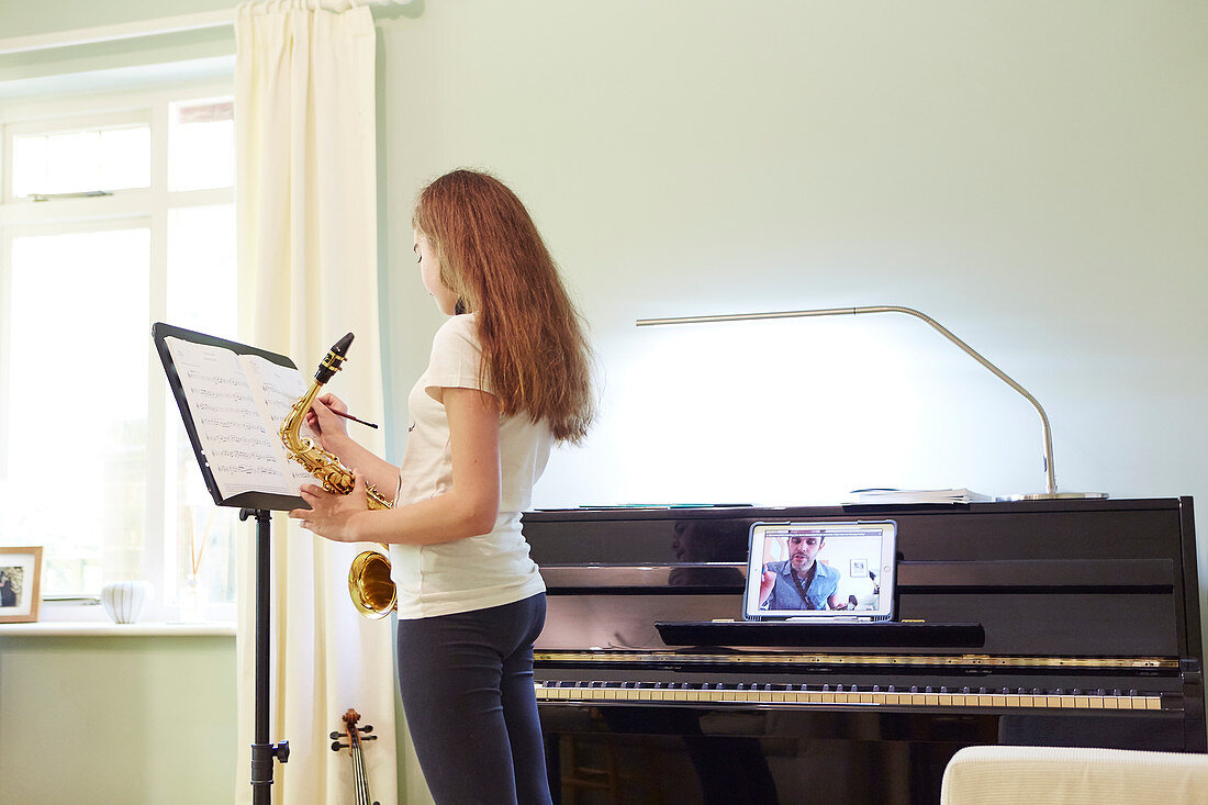 Girl taking online saxophone lesson at home