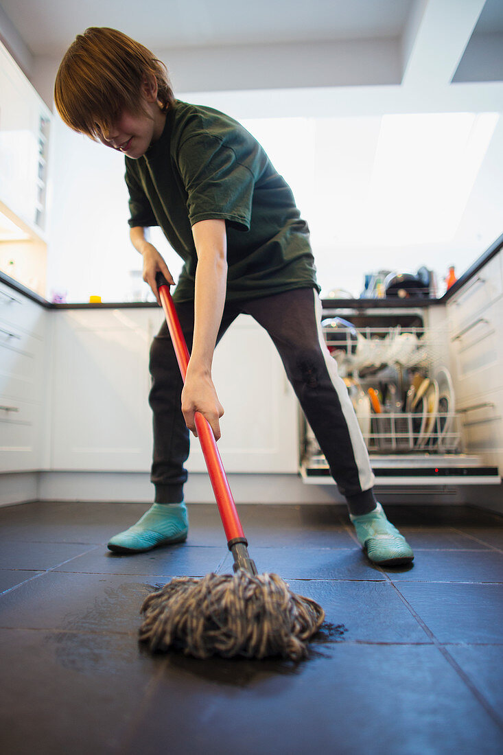 Boy mopping kitchen floor