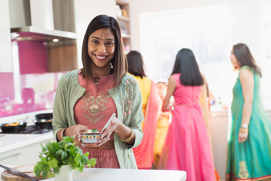 Happy Indian woman in sari and bind cooking food in kitchen