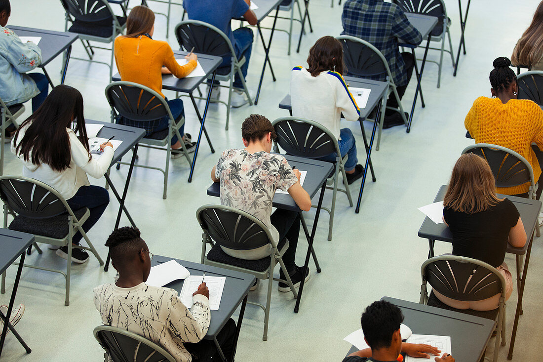 High school students taking exam at tables