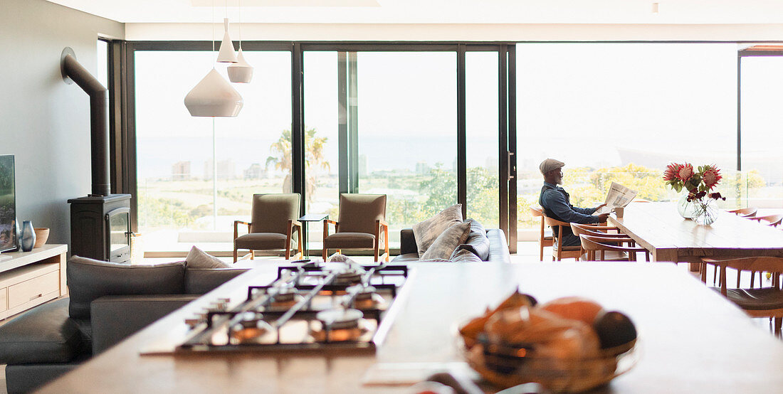 Man reading newspaper at dining table