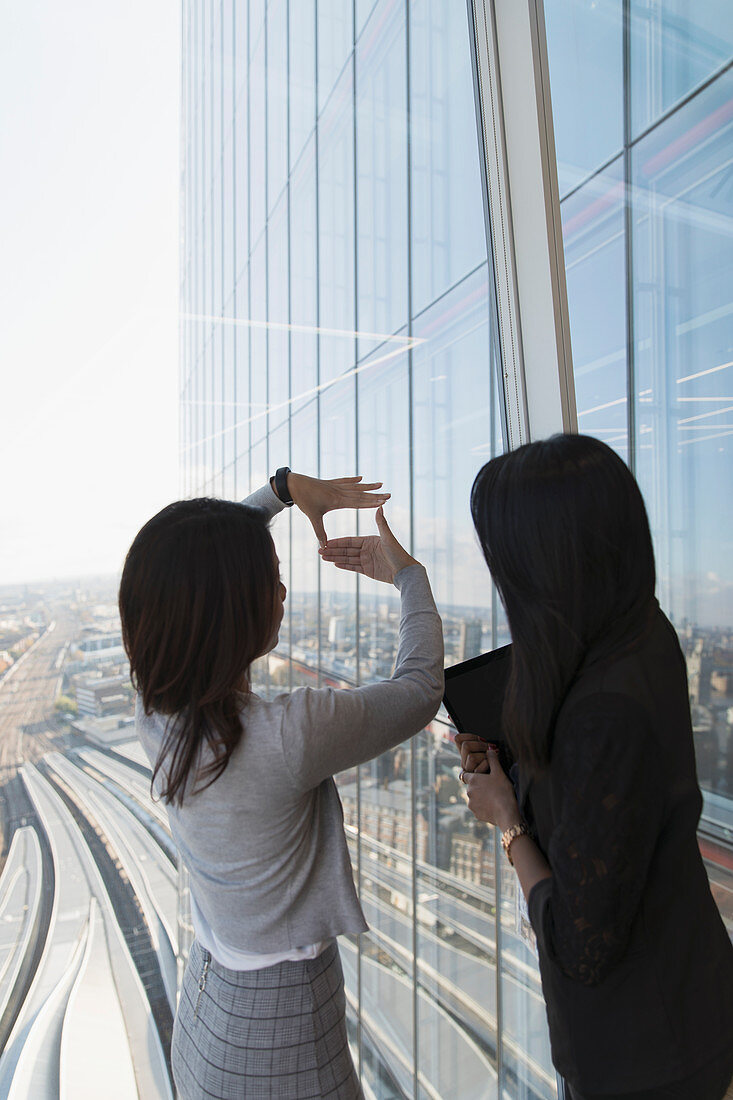 Businesswomen talking at highrise office window