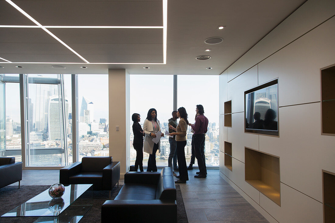 Business people talking in highrise office lobby