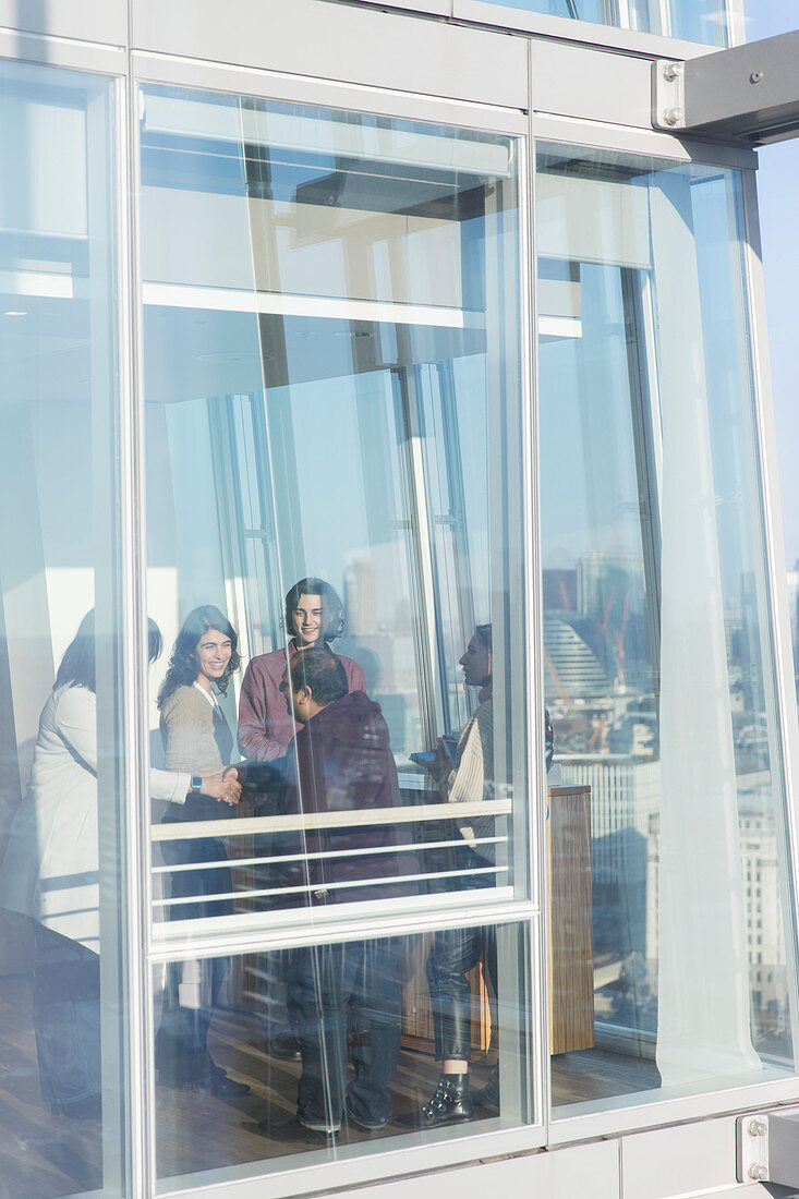 Business people talking at sunny office window