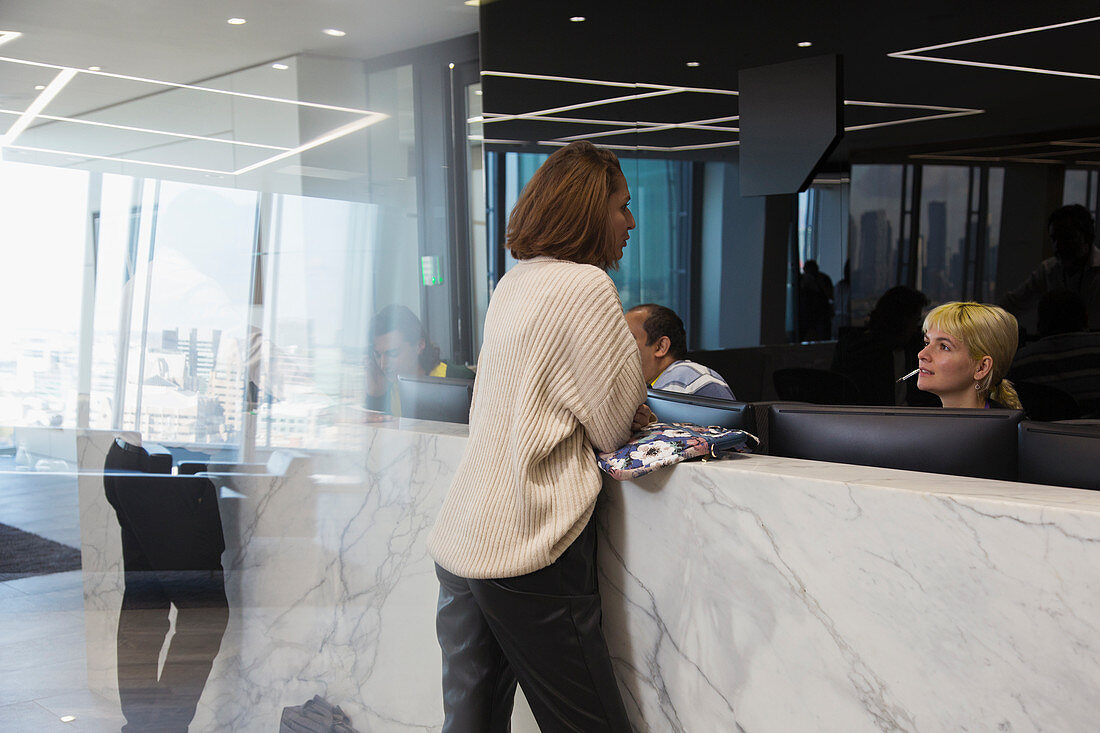 Businesswoman talking with receptionist lobby