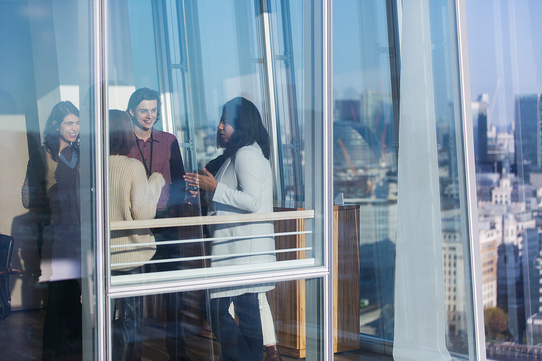 Business people talking at urban office window