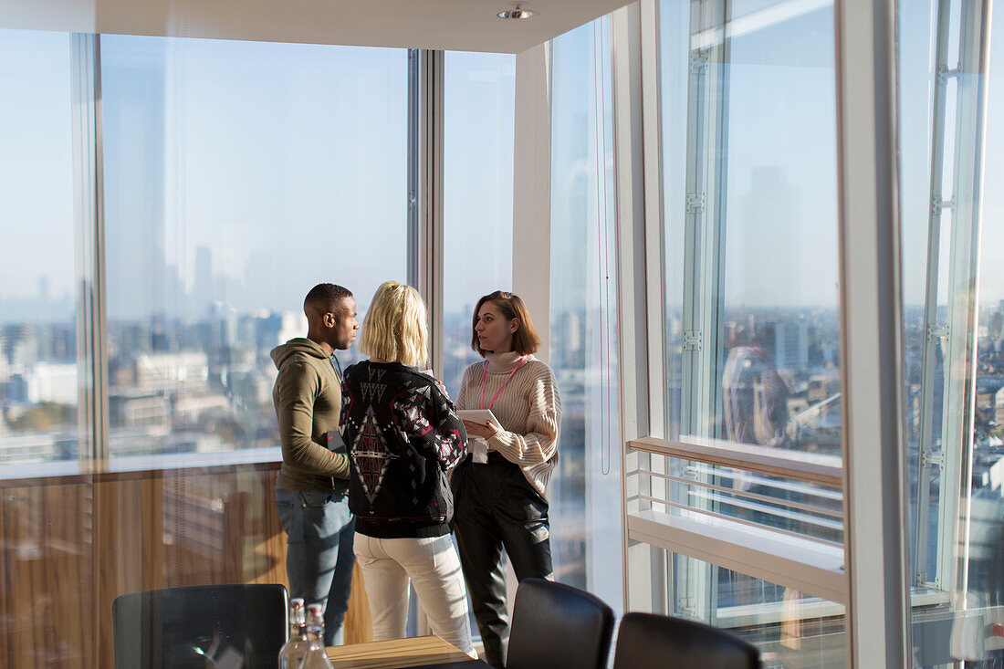 Business people talking at highrise office window