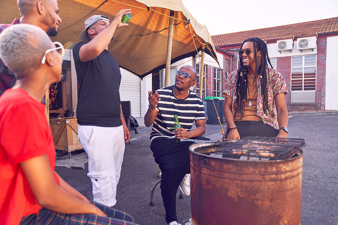 Friends hanging out and barbecuing in parking lot