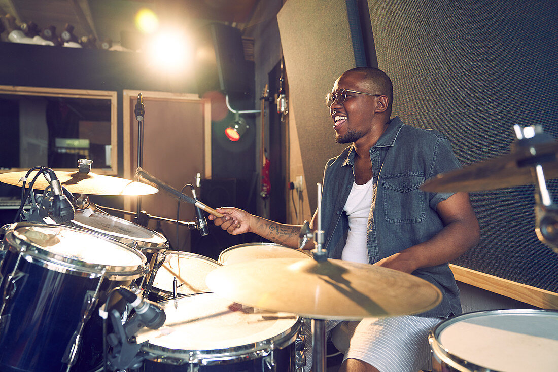 Male musician playing drums in recording studio