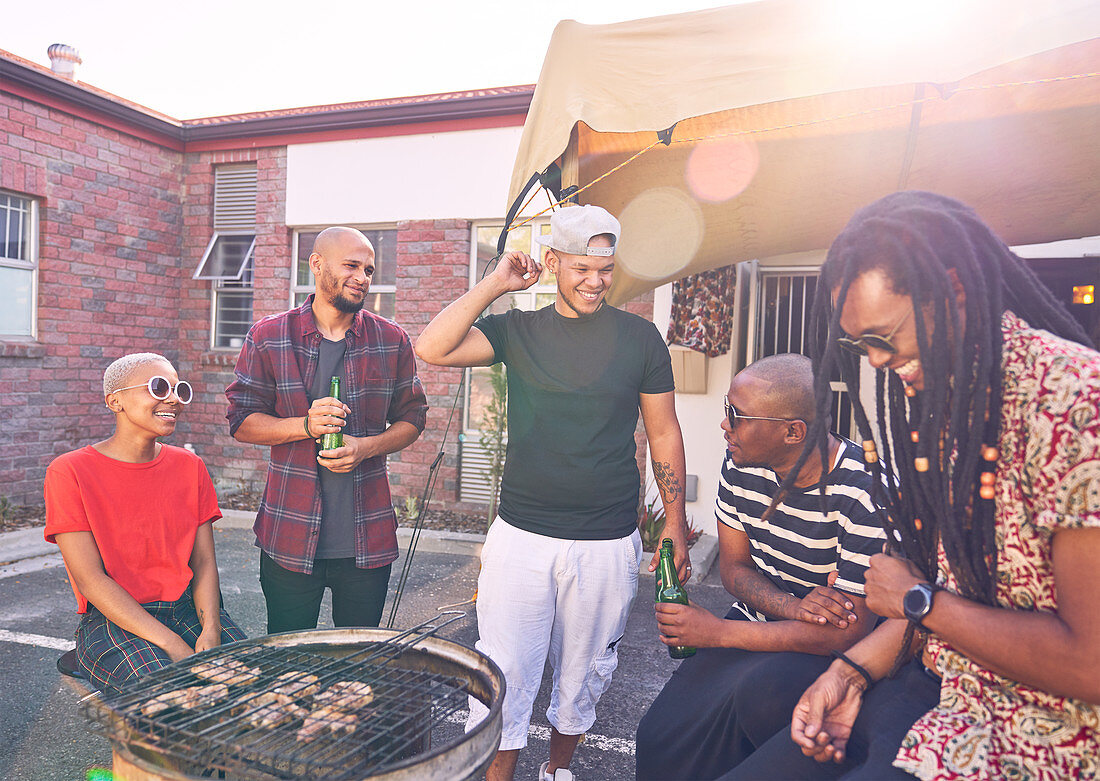 Friends barbecuing in sunny parking lot