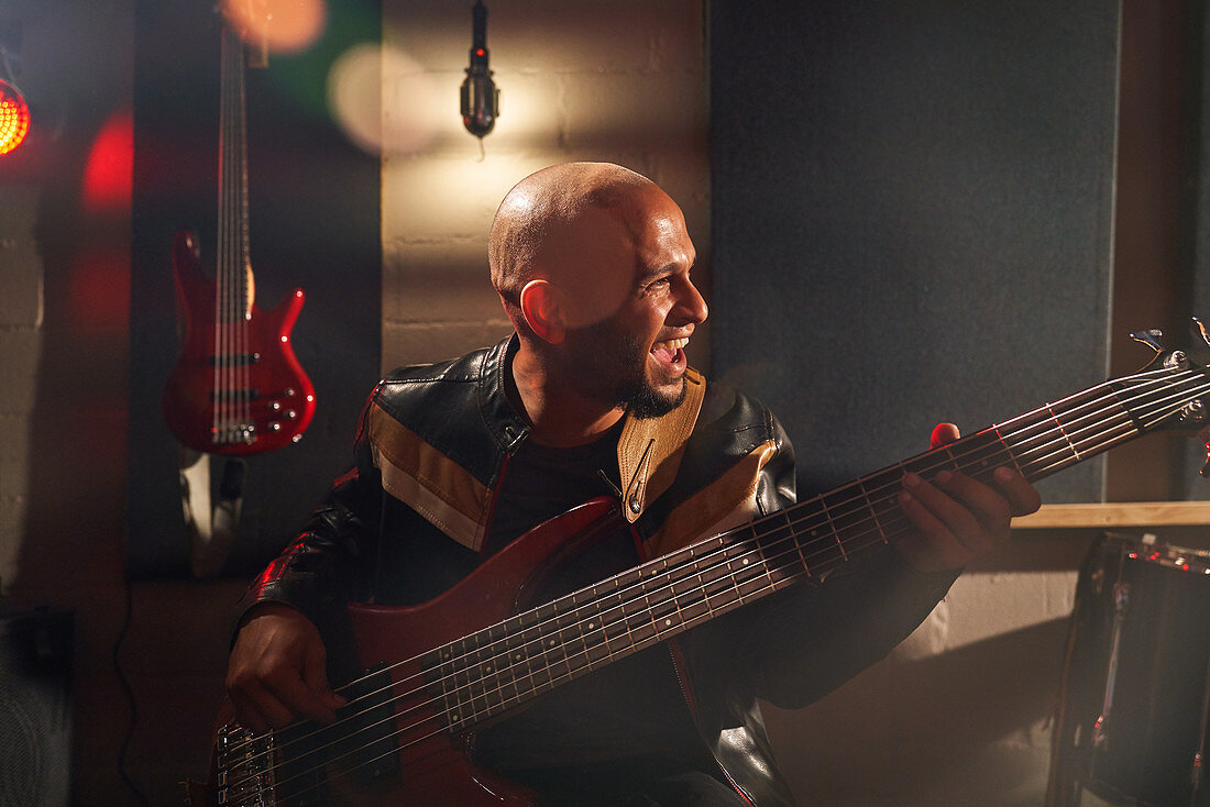 Male musician playing guitar in recording studio