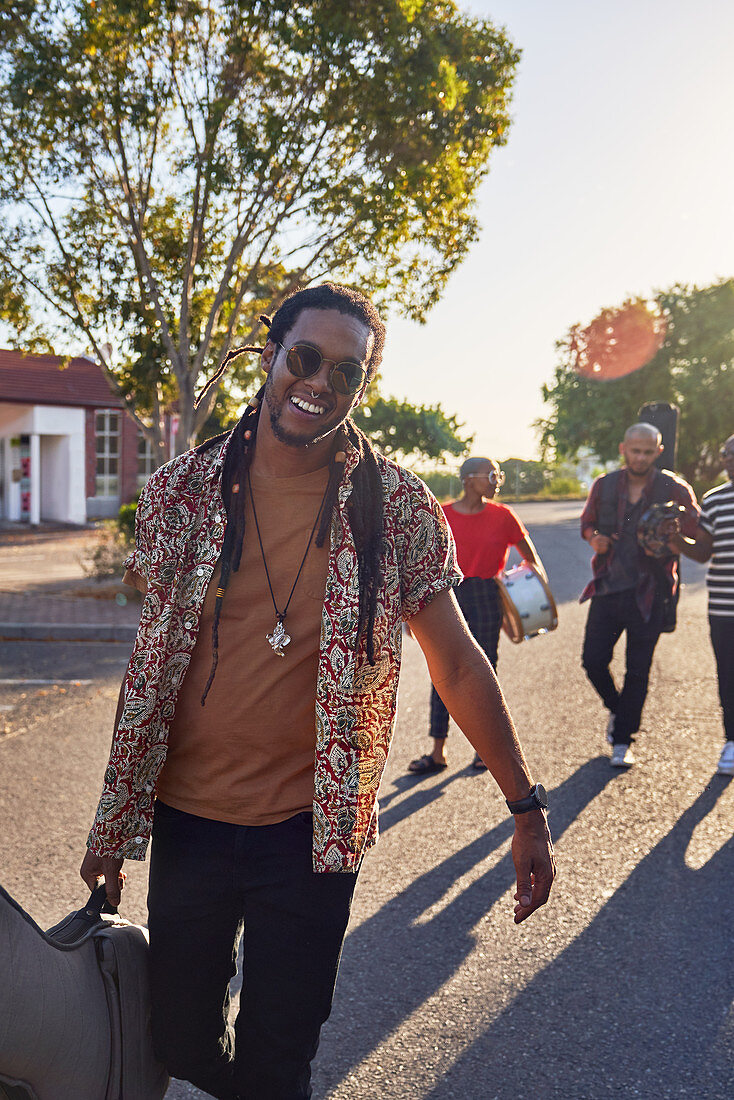 Musician carrying guitar case in street